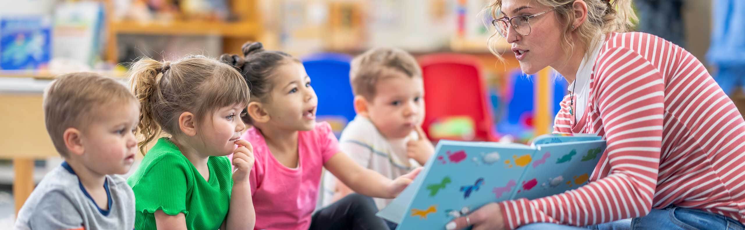 a teacher reading to a class of young children