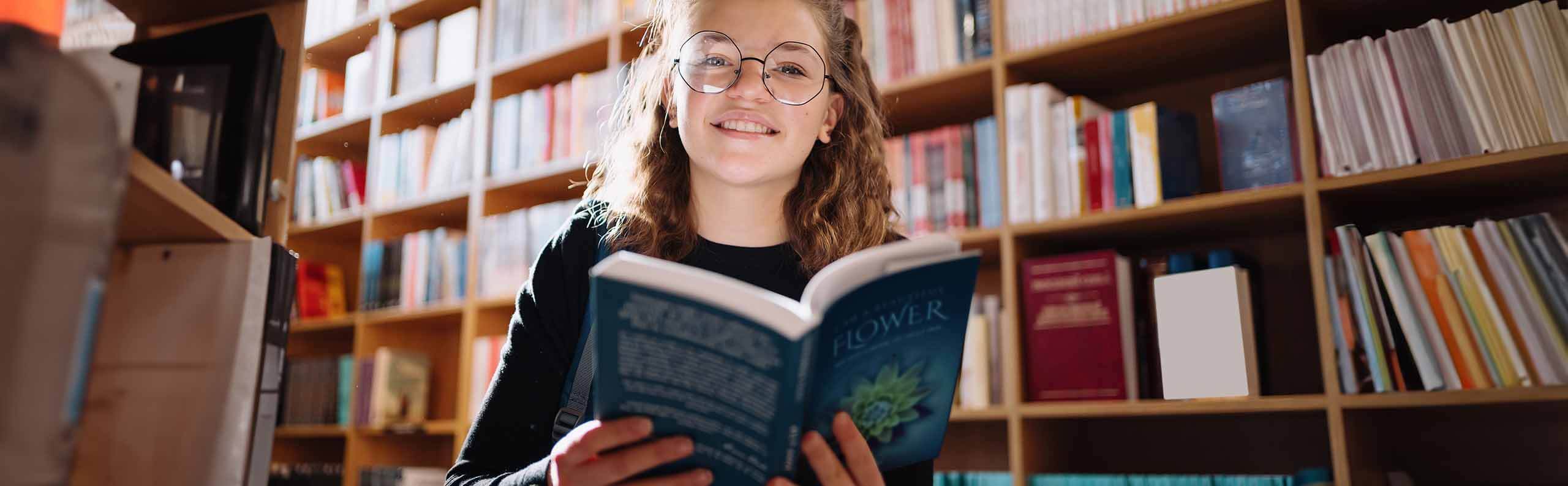 a teenager reading in a library