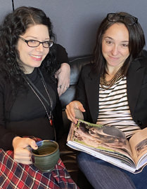 two designers holding a book